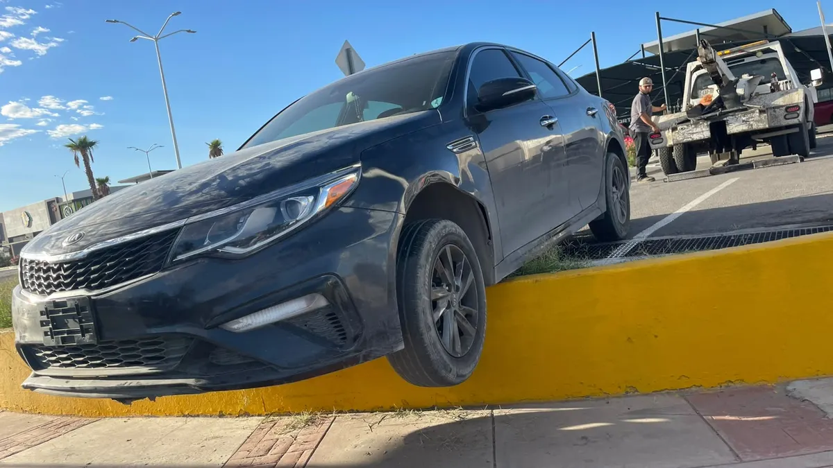 Localizan Kia Optima al borde de banqueta con llantas colgando