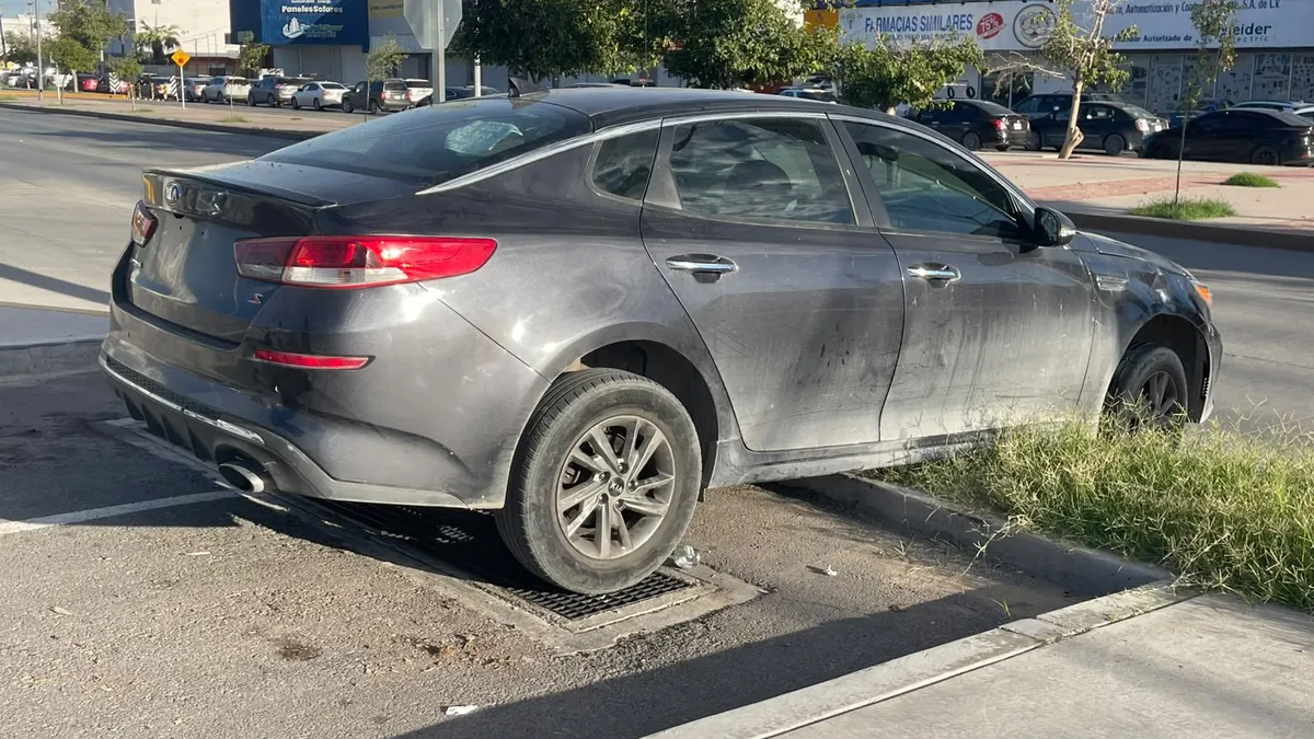 Localizan Kia Optima al borde de banqueta con llantas colgando