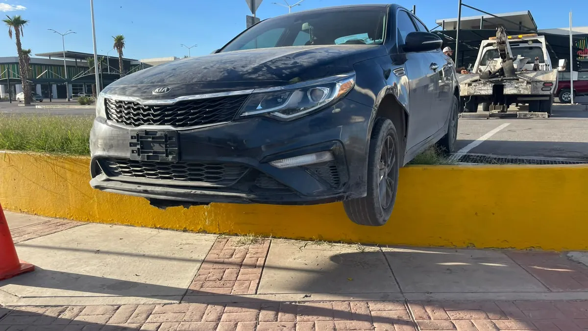 Localizan Kia Optima al borde de banqueta con llantas colgando