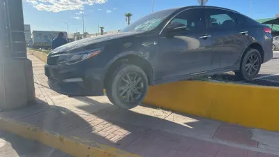 Localizan Kia Optima al borde de banqueta con llantas colgando