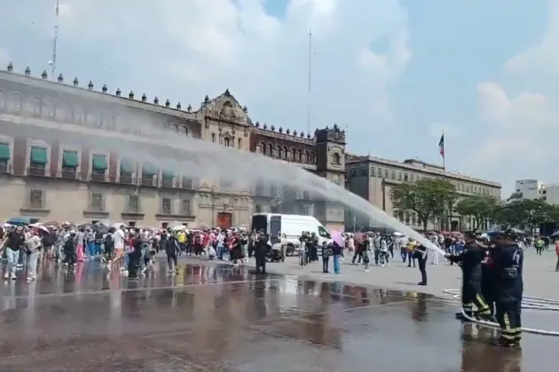 Bomberos 'bañan' a Armys en el Zócalo durante histórica visita de BTS